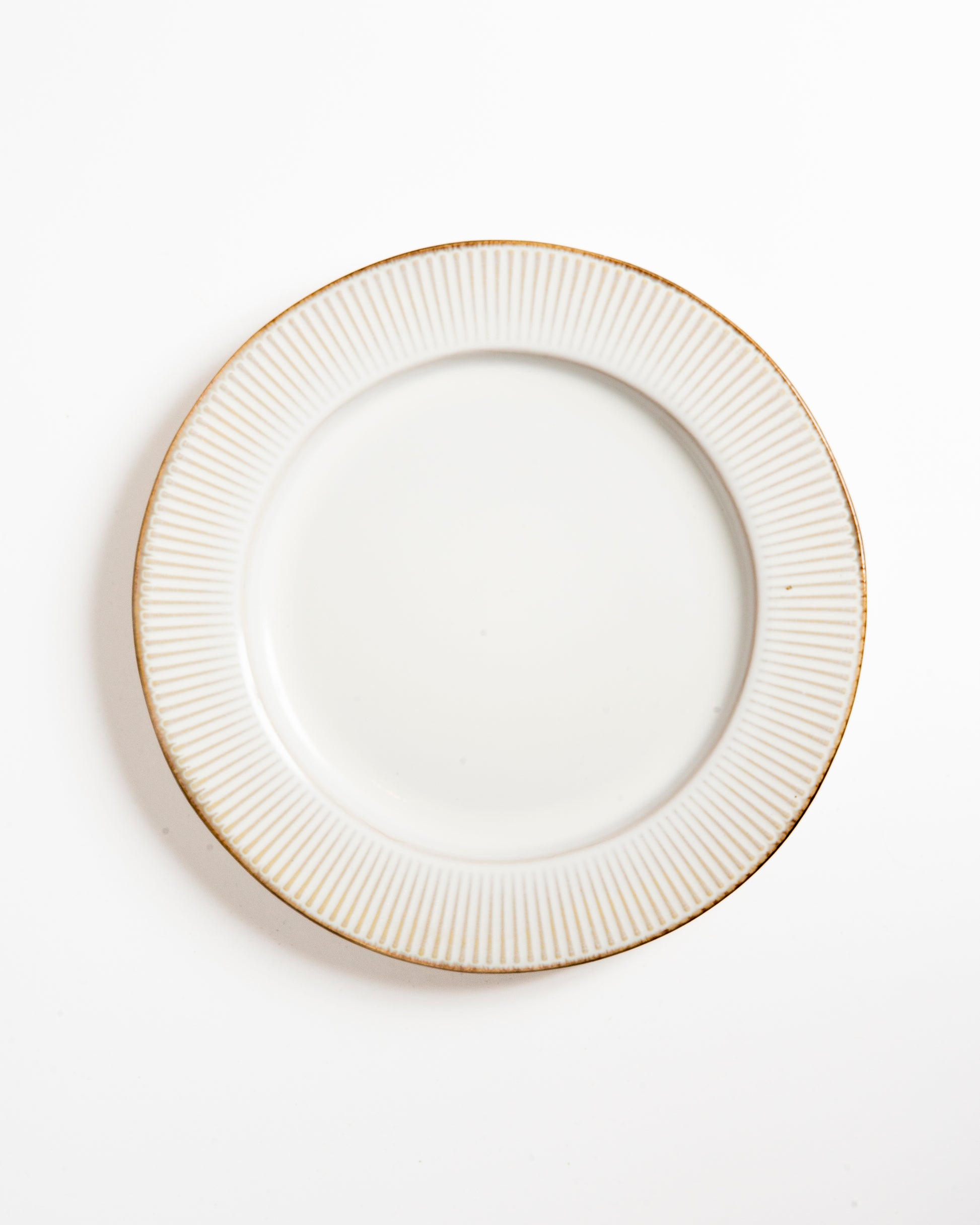 Assiette artisanale blanche à bord strié doré