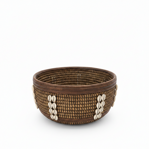 Corbeille ronde en jonc tressé brun avec cauris blancs cousus, artisanat sénégalais, fond blanc