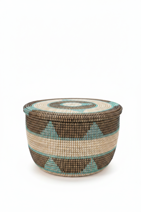 Panier de rangement rond tressé artisanal, motif géométrique africain marron et turquoise, couvercle à spirale concentrique, présenté en angle 3/4 sur fond blanc

