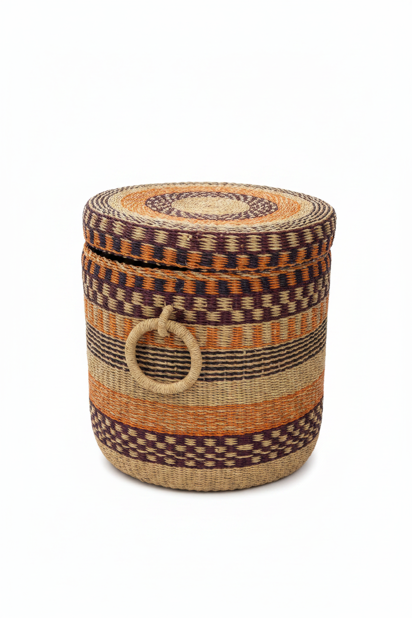 Panier artisanal africain tressé vu de profil, couvercle légèrement soulevé — bandes horizontales multicolores en raphia naturel, orange et bordeaux, anse latérale visible, fond blanc
