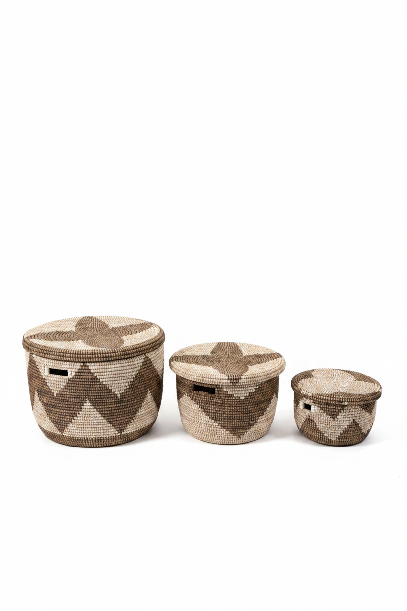 Trio de paniers de rangement artisanaux tressés en jonc de mer, motifs géométriques chevrons et étoiles en brun chocolat sur fond écru, couvercles inclus, trois tailles — grand, moyen, petit — fond studio blanc